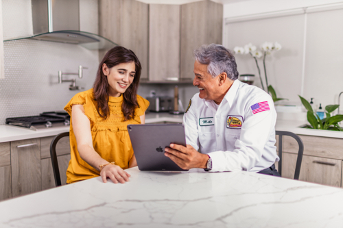 Mr. Sparky electrician with customer showing results of Electrical Home safety inspection in Gainesville, FL.