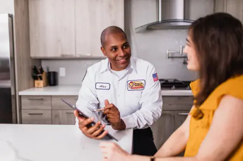 Mister Sparky Electrician Tech, Alex, speaking to a female homeowner in Gainesville, FL
